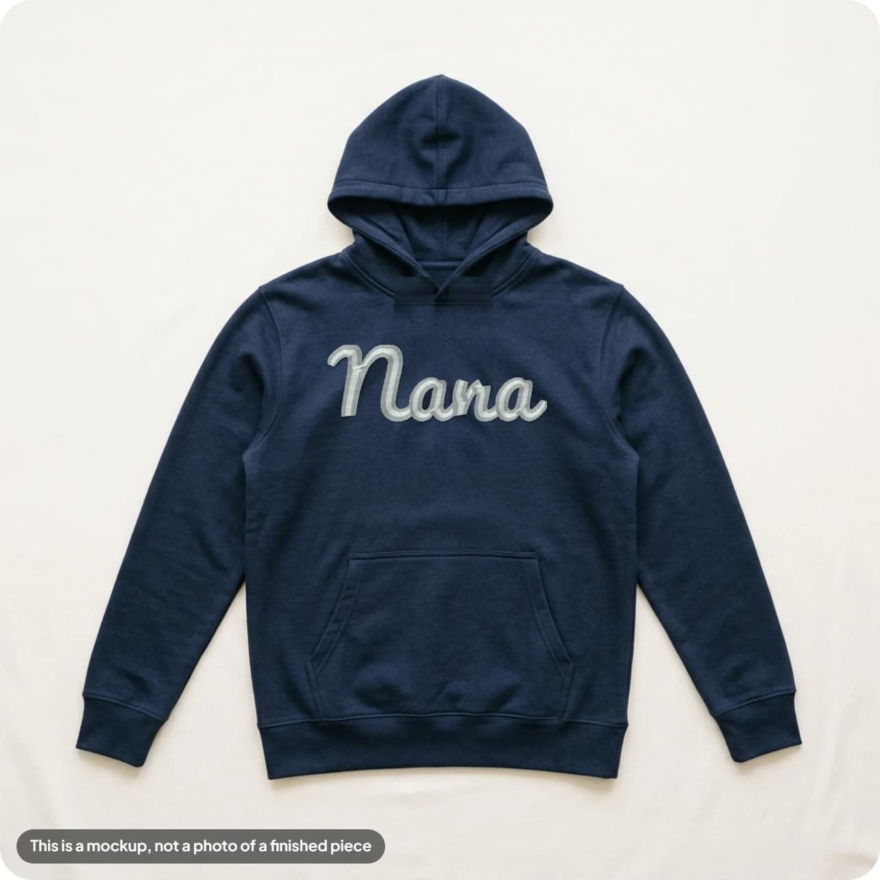 An approved mockup: a name in light thread on a navy hoodie